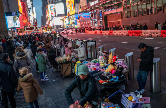 People display merchandise for pedestrians around Times Square, in New York, U.S., December 25, 2023.